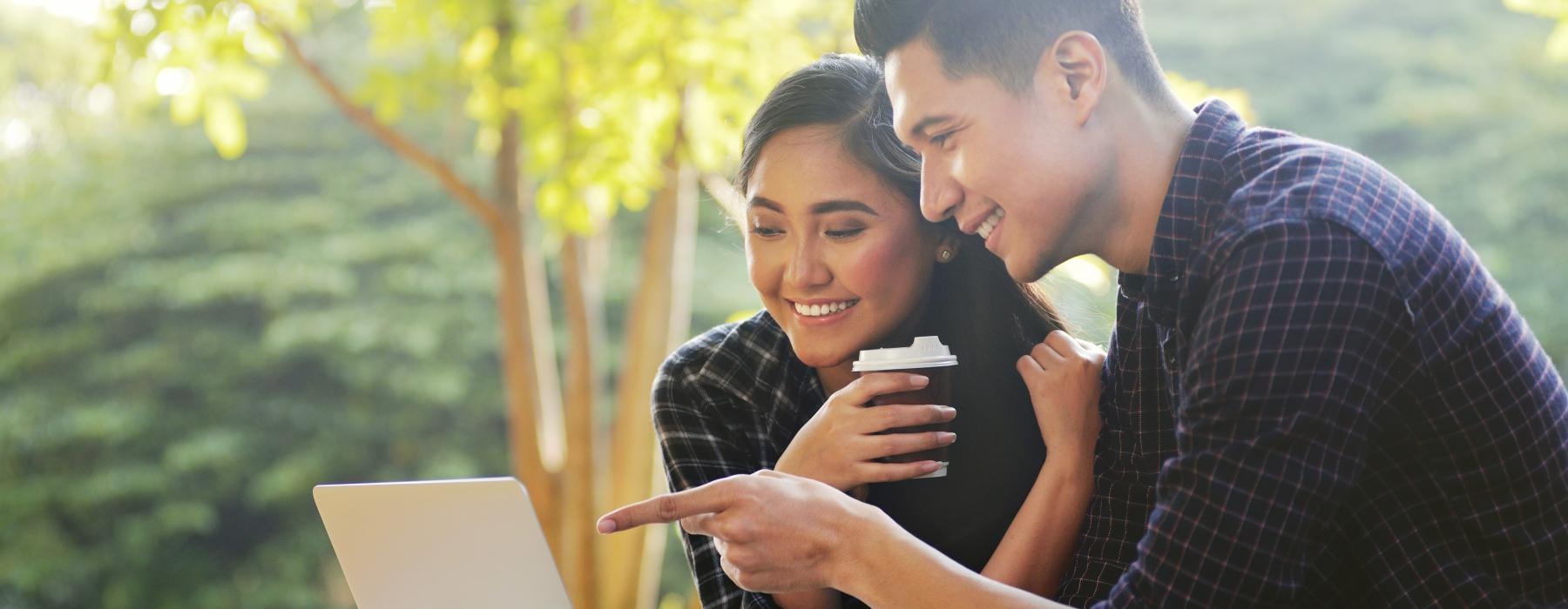 a man and a woman looking at a laptop